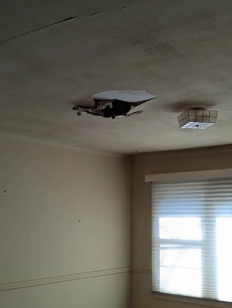 Bedroom ceiling with a large hole in the drywall, Westbury, NY