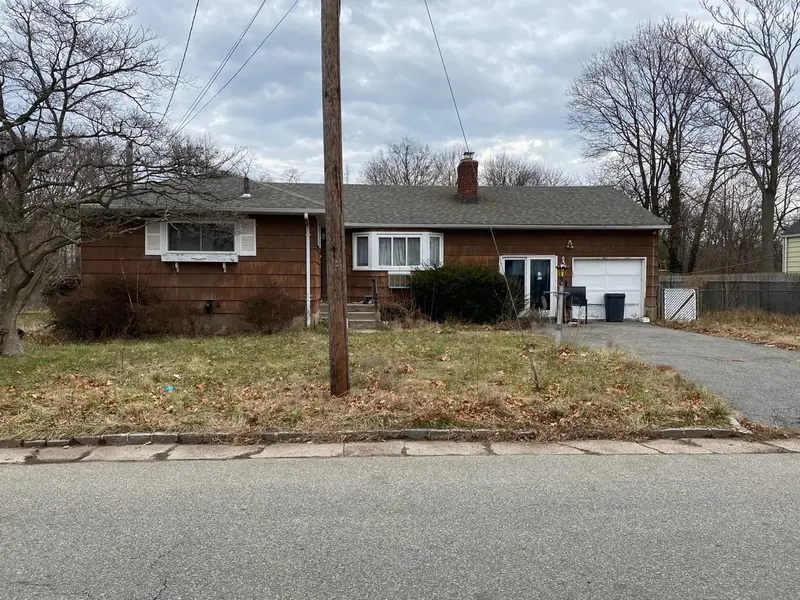 Brown shingled ranch with an unkempt front lawn, Westbury, NY